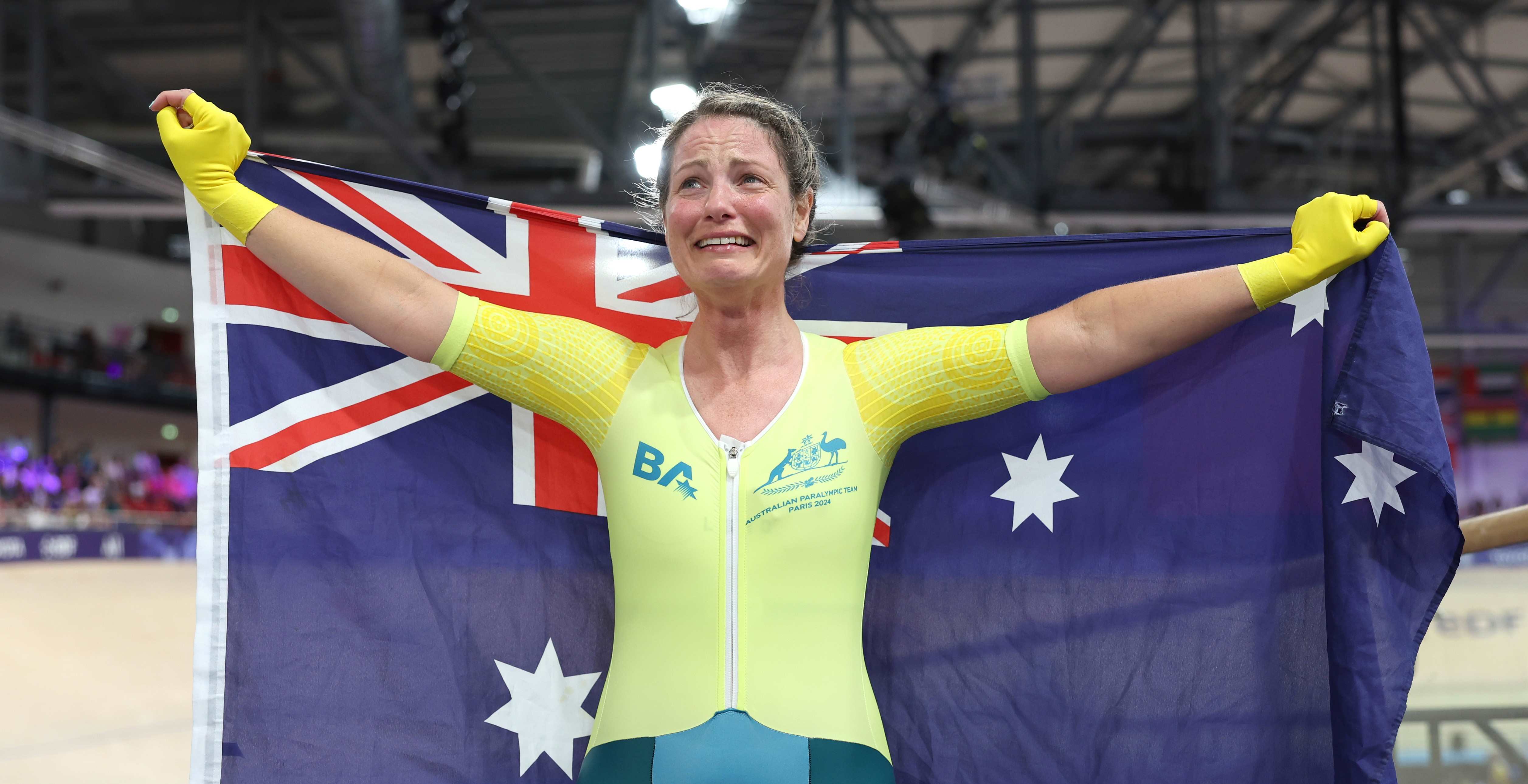 Emily Petricola of Team Australia celebrates with the flag of Australia after winning the Women's C4 3000m Individual Pursuit Final on day two of the Paris 2024 Summer Paralympic Games.